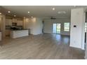 Open-concept living space with wood-look floors, white walls, and a kitchen island at 1037 Jase Dr., Longs, SC 29568