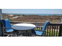 Inviting condo balcony with blue chairs and a white table, offering a relaxing spot to enjoy the ocean view at 1311 S Ocean Blvd. # B-1, North Myrtle Beach, SC 29582
