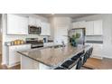 Modern kitchen featuring white cabinetry, stainless steel appliances, and a large granite island at 1426 Nokota Dr., Conway, SC 29526