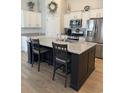 Spacious kitchen featuring a large center island with bar seating, stainless steel appliances, and ample cabinet space at 1565 Jardine Loop, Little River, SC 29566