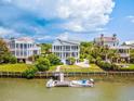 Waterfront view of multiple homes with boats docked along a calm waterway at 172 Colony Point Dr., Georgetown, SC 29440