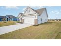 Side view of the home featuring a two-car garage with a paved driveway at 178 Six Mile Creek Dr., Georgetown, SC 29440