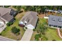 Aerial view of a well-maintained property surrounded by lush trees and neighboring homes at 205 Carriage Lake Dr., Little River, SC 29566