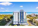 Exterior of white and blue condo building with many windows offering beautiful beach and ocean views at 215 77Th Ave. N # 702, Myrtle Beach, SC 29572