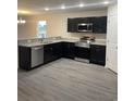 Modern kitchen boasts stainless steel appliances, granite countertops, and dark cabinetry at 2247 Union Church Rd., Little River, SC 29566
