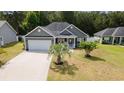 Charming single-story home with gray siding, well-manicured lawn, and a two-car garage at 247 Dempsey Dr., Loris, SC 29569