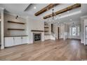 Spacious living room featuring hardwood floors, a stone fireplace, and custom built-in shelves at 404 Plantation Oaks Dr., Myrtle Beach, SC 29579