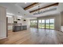 Open concept living area boasts wood floors, beamed ceilings, and sliding glass doors to outdoor space at 404 Plantation Oaks Dr., Myrtle Beach, SC 29579