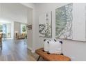 Hallway with decorative artwork and a woven bench leading into a light and airy living space at 489 Blissful Ln., Little River, SC 29566