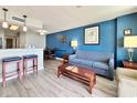 Comfortable living room with blue accent wall, dining area, and breakfast bar at 5300 N Ocean Blvd. # 1102, Myrtle Beach, SC 29577