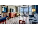 Cozy living room featuring ocean views, comfortable seating, a TV, and access to the balcony at 5300 Ocean Blvd. N # 903, Myrtle Beach, SC 29577