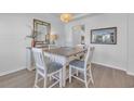 Bright dining room with wood floors, white chairs, and a rustic-style dining table at 5545 Whitebark Dr., Myrtle Beach, SC 29577