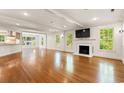 Spacious living room with hardwood floors, fireplace, and abundant natural light from multiple windows at 54 River Birch Ln., Pawleys Island, SC 29585