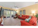 A vibrant living room with a comfortable red sofa and a scenic view from the sliding glass doors at 601 Hillside Dr. # 4424, North Myrtle Beach, SC 29582