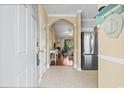 Inviting condo entrance with tile floors, stainless steel refrigerator and view into the living room at 6015 Catalina Dr. # 332, North Myrtle Beach, SC 29582