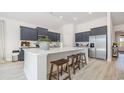 Open-concept kitchen featuring a large center island, stainless steel appliances, and stylish gray cabinets at 7119 Shooting Star Way, Myrtle Beach, SC 29579