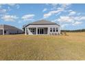 Rear exterior view of the home showcasing a simple backyard, windows and neutral siding at 748 Choctaw Dr., Conway, SC 29526