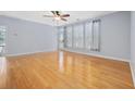 Bright living room with hardwood floors, a ceiling fan, a sliding glass door, and large windows at 854 Falkirk St., Myrtle Beach, SC 29579