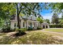 Traditional two-story home with a inviting front porch, complemented by lush landscaping and mature trees at 9340 Lake Dr., Myrtle Beach, SC 29572