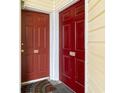 Close-up of two red entry doors, numbered 102 and 103, indicating separate units in the building at 1100 Possum Trot Rd. # B102, North Myrtle Beach, SC 29582