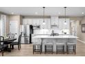 Bright, open kitchen featuring a large center island with seating, white cabinets, and stainless steel appliances at 1324 Piper Glen Dr, Sunset Beach, NC 28468