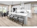 Bright, open kitchen featuring a large center island with seating, white cabinets, and stainless steel appliances at 1324 Piper Glen Dr, Sunset Beach, NC 28468