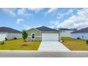 Charming home with light green siding, a modern white garage door, and a neatly kept lawn at 1372 Palm Springs Paloma Dr, Longs, SC 29568