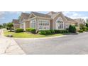 Beautiful tan home exterior featuring meticulously maintained landscaping and lovely window design at 1435 Saint Thomas Circle # E-1, Myrtle Beach, SC 29577