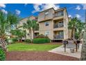 Rear of the condo complex with grilling area, patio and lush landscaping at 1582 S Waccamaw Dr. # 34, Garden City Beach, SC 29576