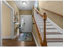 Inviting entryway features hardwood floors, staircase with white risers, and a colorful accent rug at 1614 Cottage Cove Circle, North Myrtle Beach, SC 29582