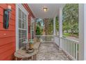 Covered front porch with slate tile, white railing, bench and decor at 212 Greenwich Dr., Conway, SC 29526