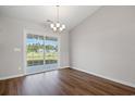 Bright dining room with wood floors, modern lighting, and sliding glass doors leading to the backyard at 271 Stillbrook Dr., Longs, SC 29568