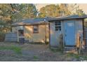 Rear view of home features a small outbuilding and overgrown yard at 414 E Wine St., Mullins, SC 29574
