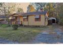 Modest single-story residence with a covered entrance and mature foliage creating privacy at 414 E Wine St., Mullins, SC 29574