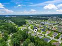 An aerial view of a neighborhood featuring mature trees, landscaping and a community pond at 424 Enderby Way, Little River, SC 29566