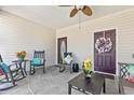 Relaxing covered porch with rocking chairs, ceiling fan, and decorative touches, creating a cozy outdoor space at 439 Colonial Trace Dr. # 119, Longs, SC 29568