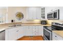 Bright kitchen features white cabinets, stainless steel appliances and hardwood floors at 4413 Plantation Harbour Dr. # A, Little River, SC 29566