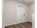 Bright foyer featuring wood-look floors, a front door with transom window, and stairway at 442 Acosta Circle, Conway, SC 29527