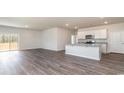 Open-concept living space with wood-look floors, island kitchen, and sliding glass door access to outdoor space at 442 Acosta Circle, Conway, SC 29527