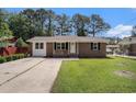 Charming brick home with a well-manicured front yard and a concrete driveway at 450 Player St., Georgetown, SC 29440