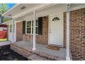Inviting front porch with brick facade, white columns, and a 'Home Sweet Home' welcome mat at 450 Player St., Georgetown, SC 29440