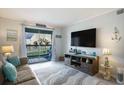 Bright living room featuring a flat screen tv, balcony access, and a cozy sofa with coastal accents at 6000 N Ocean Blvd. # 133, North Myrtle Beach, SC 29582