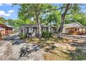 Exterior of a cozy cottage with a small porch, nestled among mature trees at 6001-N74 South Kings Hwy., Myrtle Beach, SC 29575