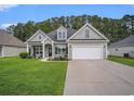 Inviting home with a well-manicured lawn, lush landscaping, and a two-car garage at 630 Heartwood Dr., Conway, SC 29526