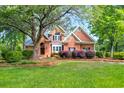 Well-maintained brick home with lush green lawn, mature trees, and symmetrical landscaping for great curb appeal at 79 Windsor Circle Sw, Ocean Isle Beach, NC 28469