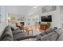 Inviting living room featuring a fireplace, hardwood floors, vaulted ceilings, and a large gray couch at 9607 Kings Grant Dr., Murrells Inlet, SC 29576