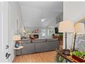 Bright living room with vaulted ceilings, a fireplace, a large gray sofa, and hardwood floors at 9607 Kings Grant Dr., Murrells Inlet, SC 29576