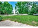 Lush backyard with a white fence and manicured lawn, ideal for recreation and relaxation at 100 Woodlyn Ave., Little River, SC 29566