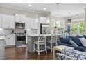 Modern kitchen with white cabinets, stainless steel appliances, a gray island with seating, and open to the living area at 1007 Longwood Bluffs Circle, Murrells Inlet, SC 29576