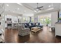 Open-concept living space with hardwood floors, a tray ceiling, and seamless transition to the kitchen and breakfast nook at 1007 Longwood Bluffs Circle, Murrells Inlet, SC 29576